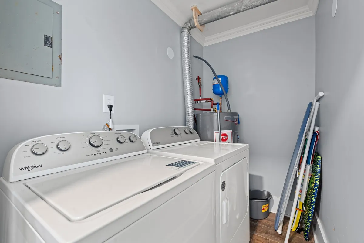 A tidy laundry area featuring a modern washing machine and dryer, with shelves stocked with laundry essentials. The scene is bright, organized, and practical, making daily chores seamless for guests.